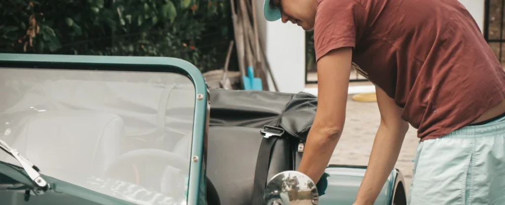 kobieta otwiera drzwi zabytkowego samochodu