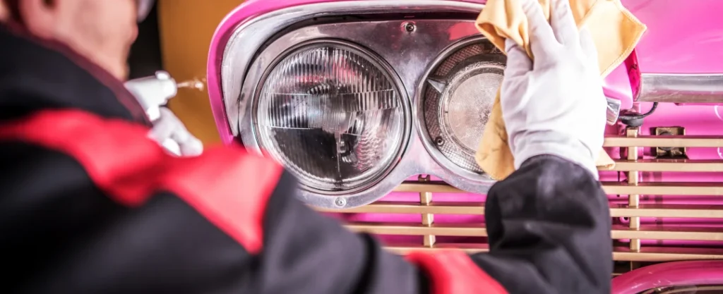mezczyzna myje lampy zabytkowego samochodu